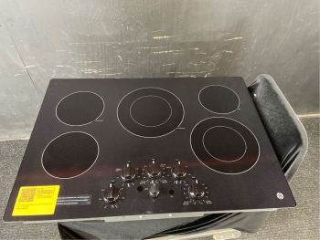 Placa de cocción eléctrica GE de 76 cm (30") con superficie lisa, perillas y 5 quemadores, color negro - JEP5030DTBBC